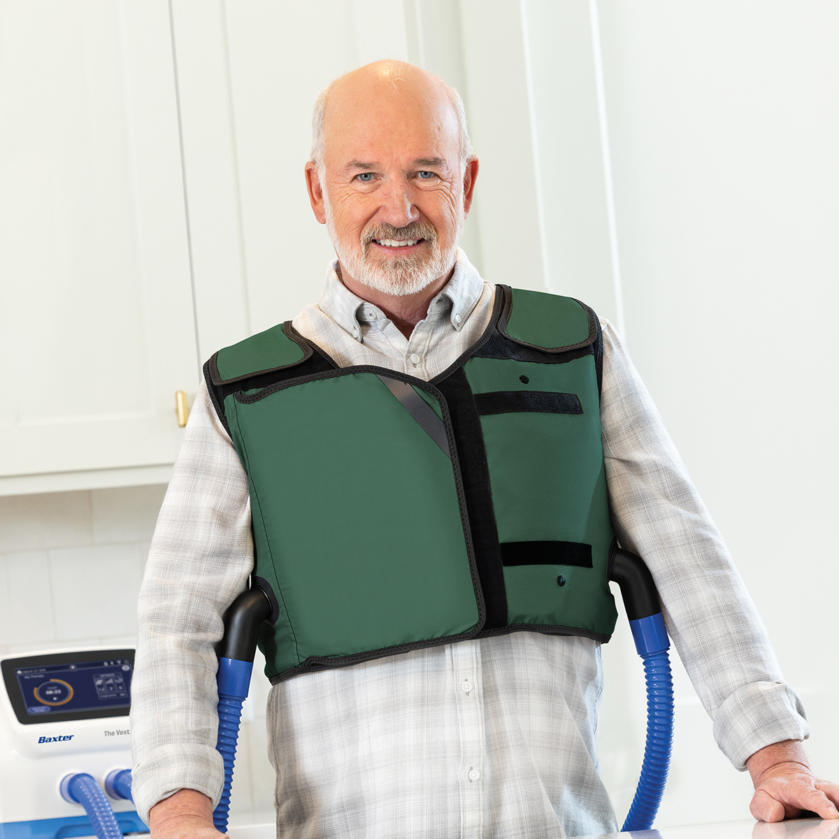 Image of an older adult patient wearing a green vest garment facing the camera